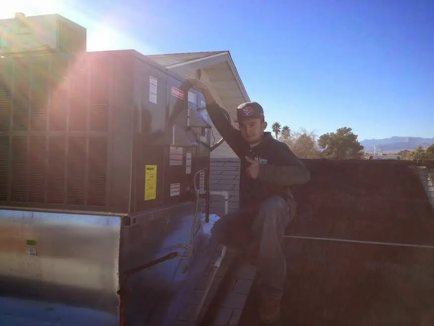 HVAC technician performing Air Duct Repair on a rooftop unit in Callaway